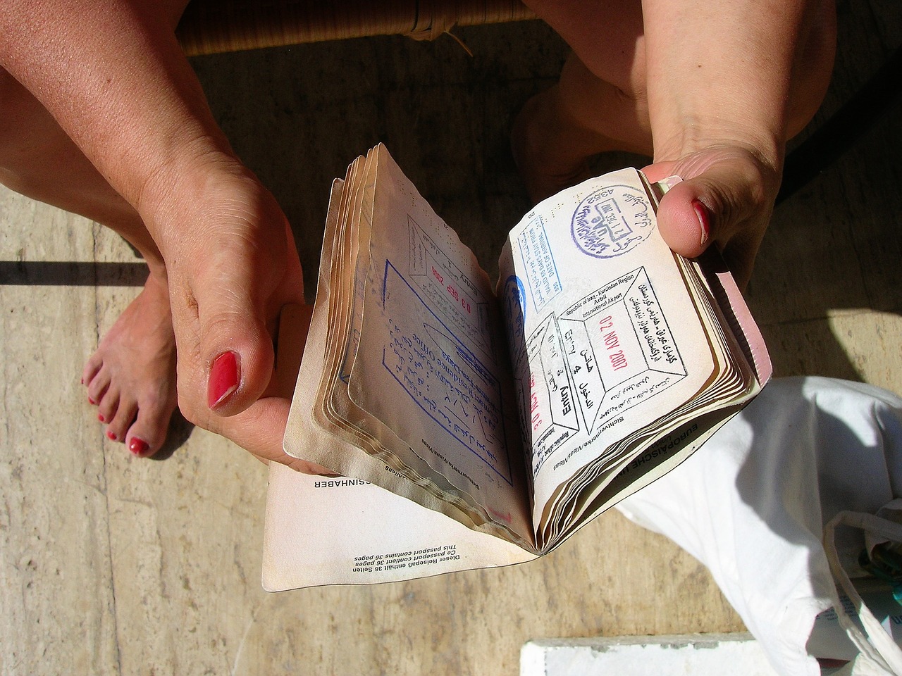 Mulher segura um passaporte: saiba todas as novidades sobre o visto E2!