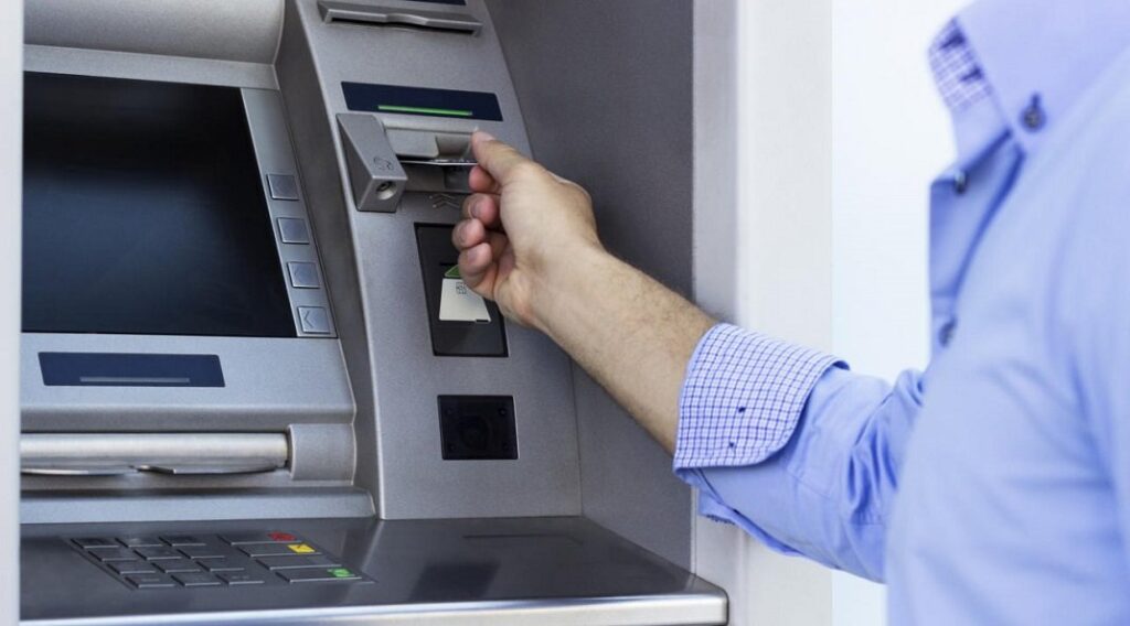 Homem insere cartão em máquina de saque eletrônico: há duas plataformas que podem realizar suas transferências bancárias para Portugal