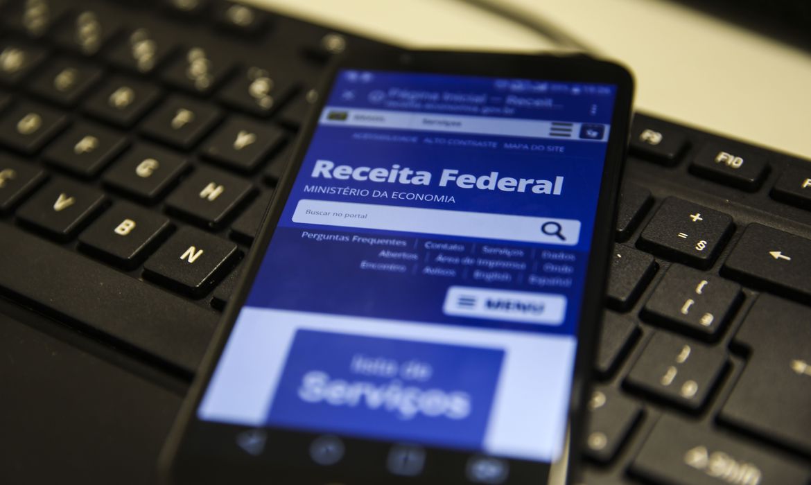 Celular exibe aplicativo da Receita Federal: é através dela que o contribuinte relata para a Receita Federal que não mora mais no país