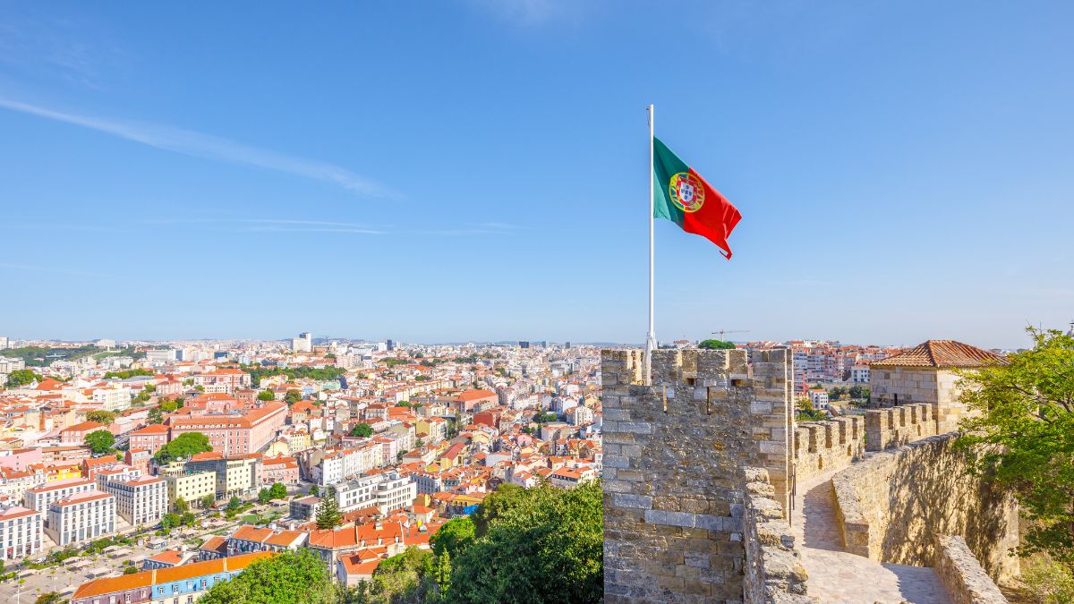 Na imagem destacada contem um castelo com a bandeira do portugal em cima e um céu azul de fundo